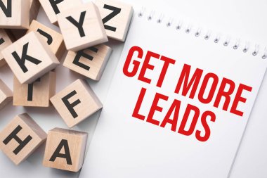Notepad with text Get More Leads and wooden cubes with letters