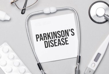 Defterde Parkinson Hastalığı, steteskop, hap ve gözlük var..