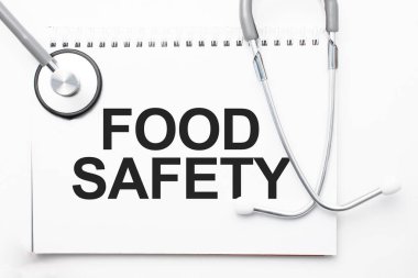 Gri steteskop ve kağıttan bir yaprak beyaz kağıt ile Gıda Güvenliği açık mavi arka plan. Tıbbi konsept.