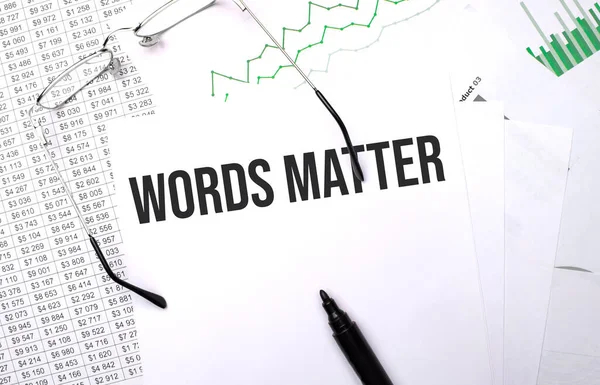 words matter . Conceptual background with chart ,papers, pen and glasses