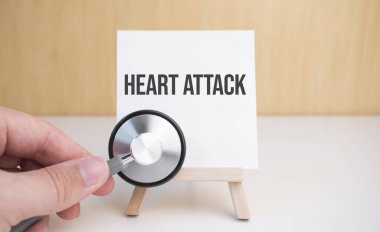 Doktor steteskop ve sehpayı kalp kriziyle tutuyor.