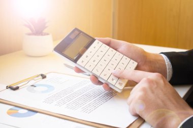 Ofiste belgelerle çalışan bir işadamı.