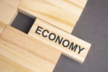 Sarı arka planda tahta bloklar üzerine ekonomi kelimeleri. İş ahlakı kavramı.