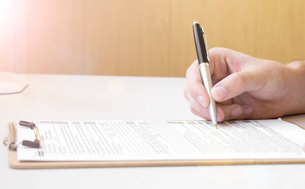 бизнесмен, работающий с финансовыми данными - ручка в руке