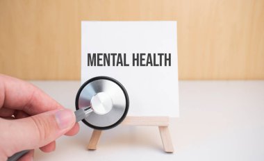 Doktor steteskop ve resim sehpası tutuyor.