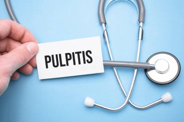 Doktorun elinde Pulpitis 'in bir eliyle yazdığı bir kartvizit var ve diğer eliyle metni gösteriyor..