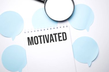 Beyaz not defteri ve mavi konuşma baloncukları. Metin motive edildi. İş konsepti