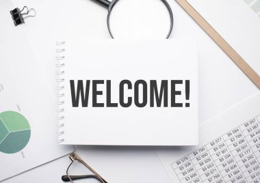 Metni yazmak için not defterine Hoşgeldin, büyüteç, çizelge ve gözlük.