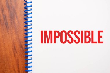 Not defterine yazılan İmkânsız metin, yukarıdan ofis ahşap tablosu, blog başlığı veya başlık resmi için konsept resmi. Yıllanmış vintage rengi görünümü.