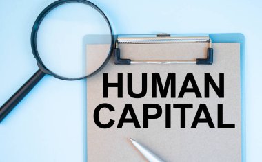 Beyaz arka plan büyüteci, bir kalem ve İnsan Sermayesi yazılı bir kağıt üzerinde. İş dünyası