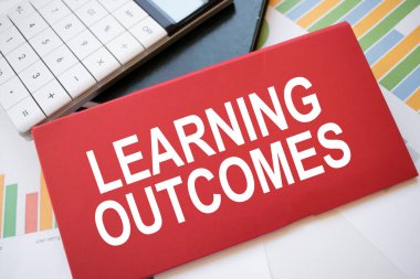 Masaüstünde metin öğrenme sonuçları, hesap makinesi ve kalem olan kırmızı kağıt sayfası. İş konsepti