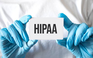 Doktorun ellerinde steteskopla hipaa metni olan beyaz etiket.