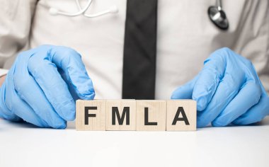 cubes with the word fmla on doctor's hand. Care concept. clipart