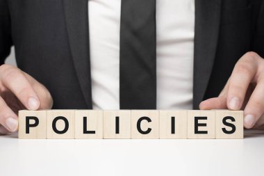 Tahta bloğu tutan bir iş adamı. İşadamı, tahta küpleri yazılı metinlerle izliyor. Finansal. finansman
