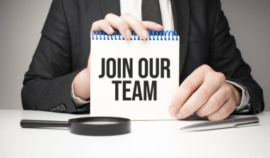 Adam gümüş bir kalem ve el sıkışma kartıyla not defterine 