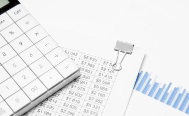 Beyaz arkaplanda hesap makinesi ve mali belgeler