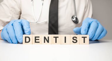 Doktor elinde tahta küplerle metin dişçisini tutuyor.