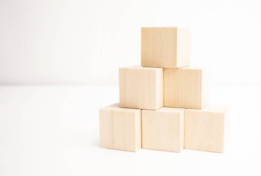Tahta bloklar beyaz arkaplanda piramit merdiveni olarak diziliyor.