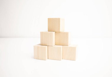 Tahta bloklar beyaz arkaplanda piramit merdiveni olarak diziliyor.