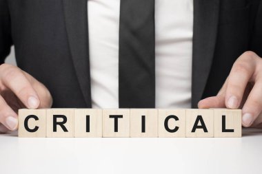 Tahta bloğu tutan bir iş adamı. İş adamı, tahta küpleri kriktali yazılı olarak izliyor. Finansal. finansman