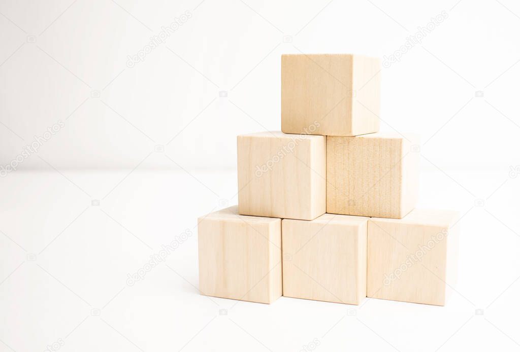 Wooden blocks stacking as a pyramid staircase on white background.