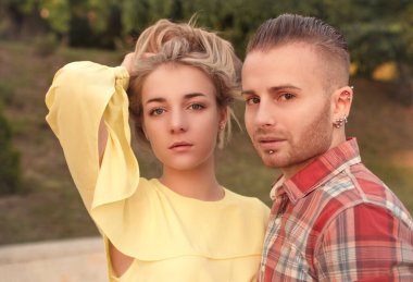 Güzel bir çift yaz gününde doğada poz veriyor.