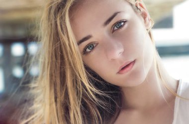 Güzel sarışın bir yaz gününde dışarıda poz veriyor.