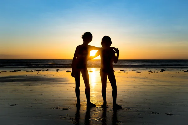 Enfants posant à la plage pendant le coucher du soleil — Photo