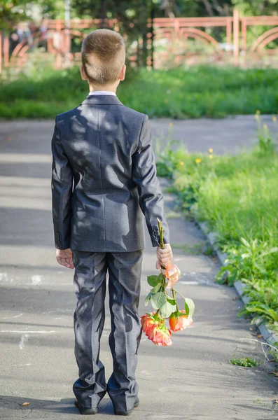 Boy with a bouquet of flowers waiting for a girl on a date — Stock Photo, Image