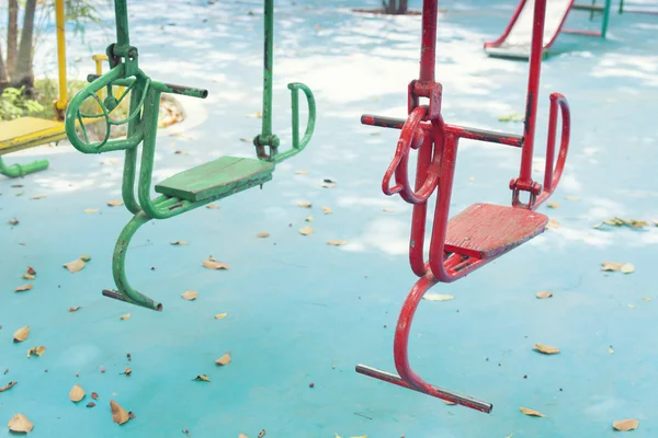 Empty hourse swings on summer kids playground — Stock Photo, Image