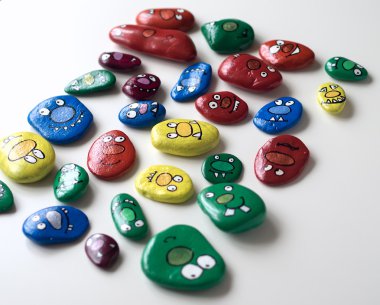 Gülümseyen yüzler canavarlar kümesi. Boyalı akrilik çakıl.