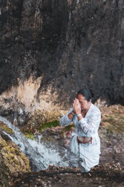 Hindulara tapan kişi kutsal su deresini yıkıyor.