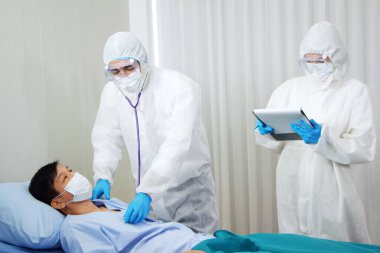 Kişisel Koruyucu Ekip veya PPE Giyim ve Araştırma ve Tartışma Ekibi Stetoskop tarafından Covid 19 virüsü kapmış hastalar için kontrol ve Tayland hastanesinde tedavi