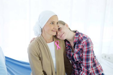 Beyaz eşarplı yaşlı annesi kemoterapiden sonra hastanede yan yana oturup gülümsüyor çünkü kanser ya da lösemi hastası..