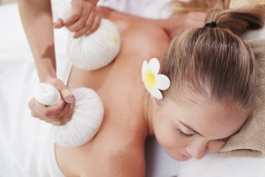 Profesyonel Asyalı Masaj Terapisti Tayland 'daki alternatif tıp tedavi merkezindeki beyaz kadına geleneksel baş ve sırt masajı yapıyor..