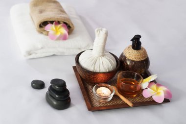 Sıcak kompres otları, atmosfer mumu, Herbals tepsisindeki bal bardağı terapi masajı için. Doğal siyah taş ve Plumeria çiçekleri Tayland 'daki alternatif tıp tedavi merkezindeki yatakta süslenir..