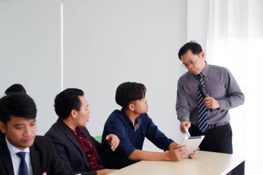 Asya 'nın kıdemli lideri iş ve pazarlama hakkında ders veriyor. İnsanlar bir seminer veriyor ve toplantı odasındaki ekonomi sınıfında tabletle bilgi araştırması yapıyorlar..