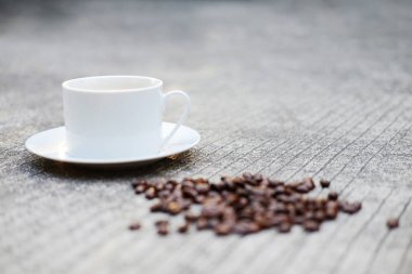 Beton zeminde beyaz seramik kahve ve fasulye. Bahçede doğal ışık sabahı. Kafein içecekleri taze bir hisse neden olur..