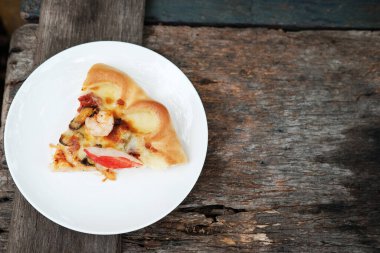 Lezzetli İtalyan yemekleri Beyaz tabakta dilimlenmiş pizza ve ahşap zemin