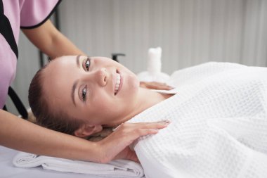 Profesyonel Asyalı Masaj Terapisti kadın, Tayland 'daki alternatif tıp tedavi merkezindeki yatakta dinleniyor ve gülümsüyor..