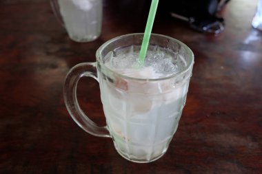 Taze hindistan cevizi suyu ve buz ve plastik tüp Tayland 'daki yerel sokak yemeklerinde klasik temiz cam..