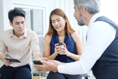 Gülümseyen genç Asyalı ve kıdemli Kafkas iş adamları, ofiste proje çalışması için tabletle birlikte toplantı ve beyin fırtınası yapıyorlar. Asyalı adama odaklan..