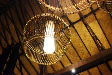Tayland 'daki tropikal tatil beldesinin ahşap tavanında asılı güzel bir rattan lambası. Asya 'da Seyahat