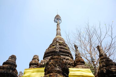 Tayland 'ın Chiangmai bölgesindeki Chiang Doa tapınağında mavi gökyüzünde Budizmin eski pagoda sembolleri.