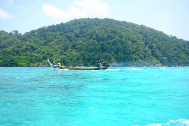 Turistleri denizden geçirmek için kullanılan yerel ahşap teknenin ve Tayland 'daki Phang Nga, Ulusal Park' taki Surin adalarındaki tropik plajların güzel manzarası.