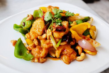 Beyaz tabakta kaju fıstıklı kızarmış tavuk. Tayland yemeği.