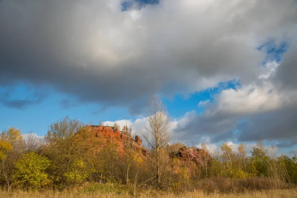 Red mountains with autumn trees and blue cloudy sky. Colored waste heaps after extracting coal from mines. — Stock Photo, Image