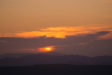 Sıcak renklerde dağlarda gün batımı.