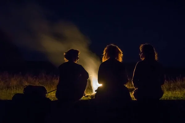 Silhouetten von Touristen am nächtlichen Feuer — Stockfoto