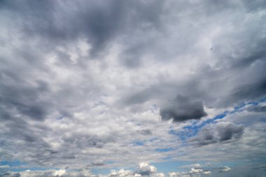 Mavi gökyüzüne karşı kara kümülüs bulutları.